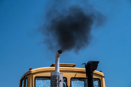 Una imagen de un camión diësel emitiendo humo negro de un tubo de escape. 